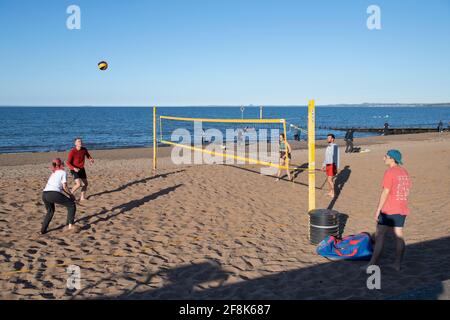 Edinburgh, Schottland, Großbritannien. April 2021. IM BILD: Volleyball am Sandstrand von Portobello. Die Menschen genießen den klaren blauen Himmel und das warme, sonnige Wetter auf der Ostseite Schottlands am Portobello Beach. Quelle: Colin Fisher/Alamy Live News Stockfoto