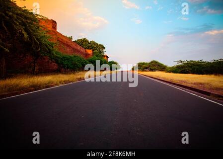 Blick auf den Weg zum Umaid Bhawan Palace durch präkambrianische Ära rot Sandsteingebirge, die in Jodhpur Group-Malani Igneous Suite Contact fällt Geologisch Stockfoto