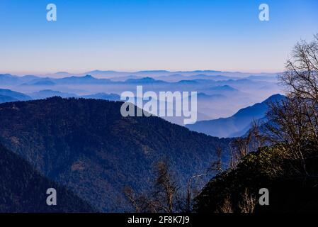 Blick auf die Himalaya-Bergkette mit sichtbaren Silhouetten durch den bunten Nebel vom Khalia Top Trek Trail. Der Gipfel von Khalia liegt auf einer Höhe von 3500m h. Stockfoto