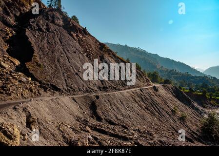 Ansicht auf gefährlichen Straßen, die zum Erdrutsch neigen, im Himalaya Mountain River Valley in Uttarakhand, Indien, unterwegs sein. Stockfoto