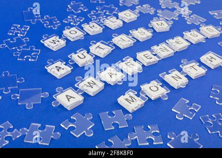 Welt Autismus Bewusstsein Hintergrund. Transparente Puzzle Details auf Inschrift auf blauem Hintergrund. Stockfoto