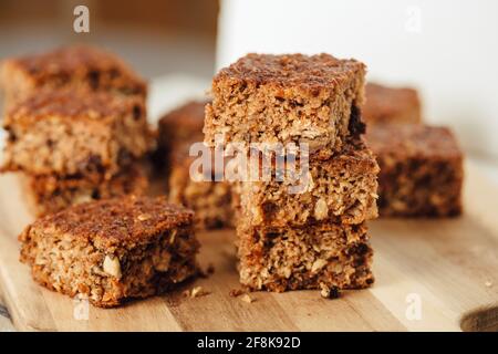 Nahaufnahme eines hausgemachten Bananenbrot-Laibs mit Walnüssen, die auf einem hölzernen Schneidebrett geschnitten wurden. Stockfoto