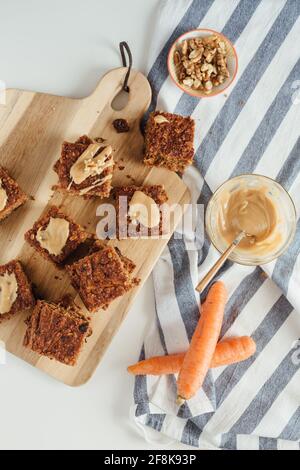 Draufsicht auf einen hausgemachten Bananenbrot-Laib mit Walnüssen, die auf einem hölzernen Schneidebrett geschnitten wurden. Stockfoto