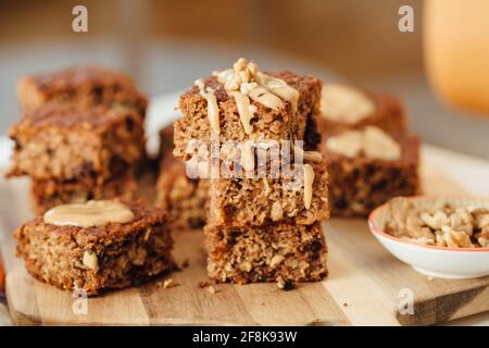 Seitenansicht eines hausgemachten Bananenbrotes mit Walnüssen, die auf einem hölzernen Schneidebrett geschnitten wurden. Stockfoto