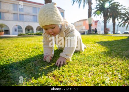 Nettes Baby Mädchen im Freien im Frühling auf Gras Stockfoto