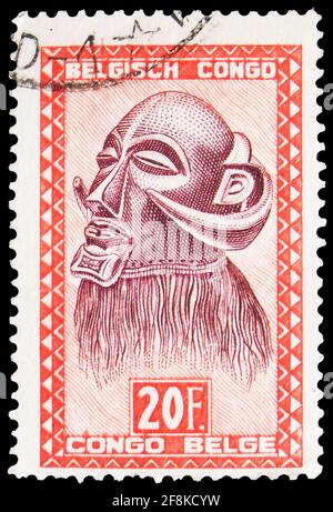 MOSKAU, RUSSLAND - 7. OKTOBER 2019: Die im belgischen Kongo gedruckte Briefmarke zeigt die Henkermaske „Mbawa“ mit Büffelhörnern, geschnitzten Figuren und Masken Stockfoto