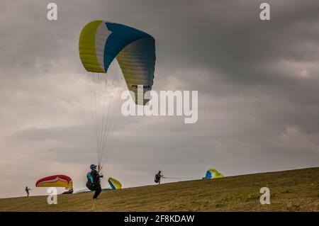 Bo Peep, Alciston, Lewes, East Sussex, Großbritannien. April 2021. Ein heller Start in den Tag mit zunehmender Wolke am Nachmittag. Kalter Wind aus dem Nordosten bringt Gleitschirmflieger nach Bo Peep auf den Southdowns weit über der herrlichen Landschaft von Sussex. Kredit: David Burr/Alamy Live Nachrichten Stockfoto