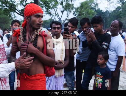 Guwahati, Assam, Indien. April 2021. Hindu-Anhänger, die während des Charak Puja-Festivals inmitten der COVID-19-Coronavirus-Pandemie in einem Dorf im Barpeta-Distrikt von Assam mit Eisenhaken durchbohrt wurden. Charak Puja ist ein hinduistisches Volksfest zu Ehren des gottes Shiva. Sie findet am letzten Tag des Monats Chaitra um Mitternacht im indischen Bundesstaat Westbengalen und im südlichen Bangladesch statt. Quelle: David Talukdar/ZUMA Wire/Alamy Live News Stockfoto