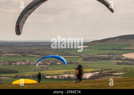 Bo Peep, Alciston, Lewes, East Sussex, Großbritannien. April 2021. Ein heller Start in den Tag mit zunehmender Wolke am Nachmittag. Kalter Wind aus dem Nordosten bringt Gleitschirmflieger nach Bo Peep auf den Southdowns weit über der herrlichen Landschaft von Sussex. Kredit: David Burr/Alamy Live Nachrichten Stockfoto