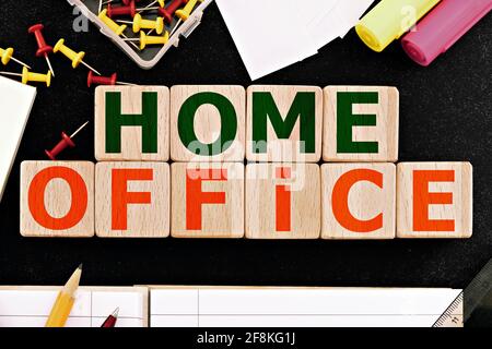 Foto zum Thema Home Office. Holzwürfel mit der Aufschrift „Home Office“, umgeben von Bürobedarf. Geschäftskonzept Bild Stockfoto