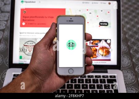 Barcelona, Katalonien, Spanien. April 2021. In dieser Abbildung wird die TripAdvisor-App auf einem Smartphone-Bildschirm mit einer TripAdvisor-Website auf einem Laptop im Hintergrund angezeigt. Quelle: Thiago Prudencio/DAX/ZUMA Wire/Alamy Live News Stockfoto
