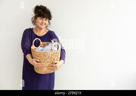 Erwachsene Brünette Frau hält Korb schmutzige Wäsche. Konzept Housekeeping.Copy Raum Stockfoto