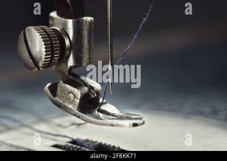 Nahaufnahme der Nähmaschinennadel mit Faden. Arbeitsteil der antiken Nähmaschine. Stockfoto