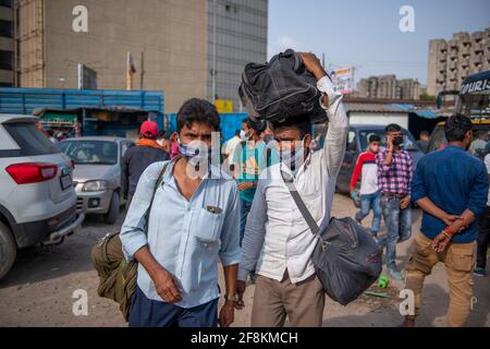 Neu-Delhi, Indien. April 2021. Migranten werden mit ihrem Gepäck auf einem Busparkplatz gesehen.Migranten eilen an Bord von Bussen, weil sie Angst vor der Sperrung in Delhi haben. Delhi berichtet über 17,282 positive Fälle und 104 Todesfälle in den letzten 24 Stunden. (Foto von Pradeep Gaur/SOPA Images/Sipa USA) Quelle: SIPA USA/Alamy Live News Stockfoto