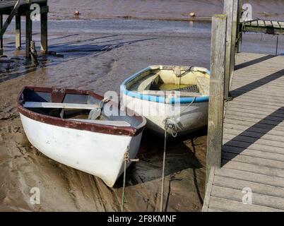 Bei Ebbe in Morston an der Nordküste Noroflks werden Boote auf dem klebrigen Schlamm des Salzsumpfs gestrandet. Stockfoto