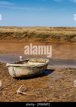 Bei Ebbe in Morston an der Nordküste Noroflks werden Boote auf dem klebrigen Schlamm des Salzsumpfs gestrandet. Stockfoto