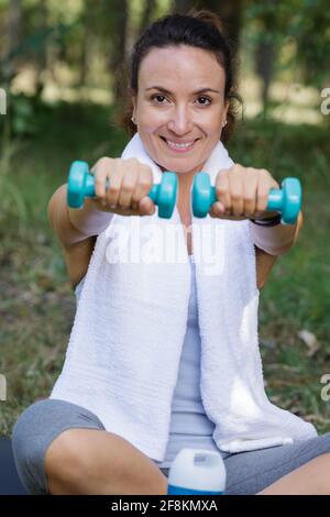 Frau trainiert mit Kurzhanteln im Park Stockfoto