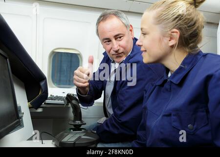 Luftfahrtingenieurin, die mit der Lehrerin an einem Hubschrauber arbeitet Stockfoto