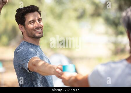 Junger Mann lächelt auf dem Campingplatz Stockfoto