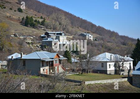 Panoramablick auf Nympaio, eine traditionelle Siedlung mit typischen Steinhäusern, Zinndächern und gepflasterten Straßen in Westmakedonien, Griechenland. Stockfoto