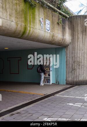 AMSTERDAM NIEDERLANDE, 11. APRIL 2021: Eine Frau, die in einem Tunnel durch die Bücher schlurft, um Fahrräder und Fußgänger zu finden Stockfoto