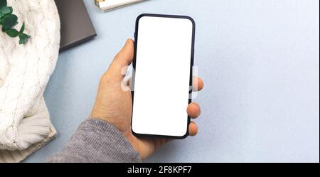 Businesss Arbeitsplatzmockup mit Smartphone in der Hand, Kopierraum und Flat Lay Design Concept Foto Stockfoto