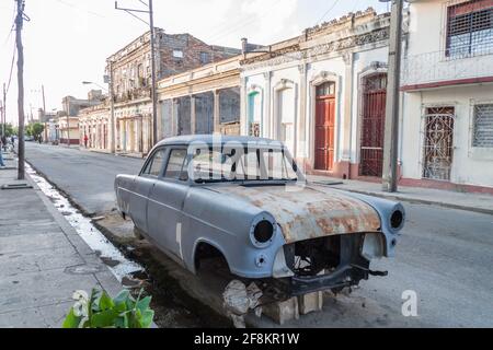 CIENFUEGOS, KUBA - 10. FEBRUAR 2016: Blick auf verfallene Häuser und ein Auto in Cienfuegos, Kuba. Stockfoto