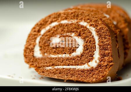 Schokoladen-Biskuitrolle mit Vanillegeschmack, Schweizer Schokoladenrolle, wirbelter Kuchen Stockfoto