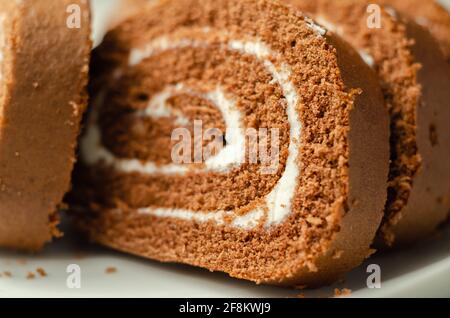 Schokoladen-Biskuitrolle mit Vanillegeschmack, Schweizer Schokoladenrolle, wirbelter Kuchen Stockfoto