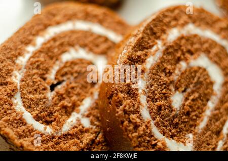 Schokoladen-Biskuitrolle mit Vanillegeschmack, Schweizer Schokoladenrolle, wirbelter Kuchen Stockfoto