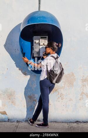 CIENFUEGOS, KUBA - 10. FEBRUAR 2016: Eine Einheimische ruft mit einem öffentlichen Telefon in Cienfuegos, Kuba, an. Stockfoto