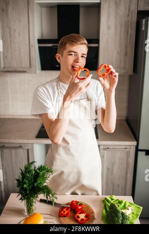 Koch Kerl bereitet veganen Salat, frischen Pfeffer, in der Küche. Gesundes Essen. Stockfoto