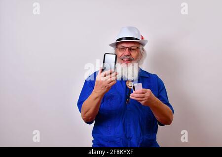 Glücklicher alter Mann mit Smartphone und Kreditkarte zu machen Online-Käufe Stockfoto