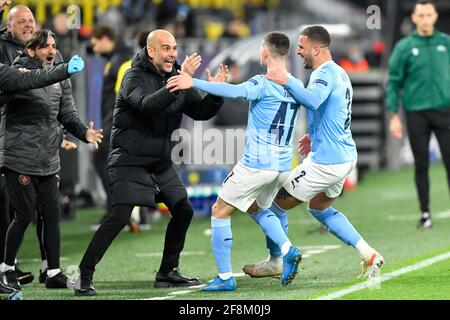 Manchester City Manager Pep Guardiola feiert mit Torschütze Phil Foden und Kyle Walker (rechts) ihr zweites Tor während des UEFA Champions League-, Viertelfinales-, zweiten Beinspieles im Signal Iduna Park in Dortmund. Bilddatum: Mittwoch, 14. April 2021. Siehe PA-Geschichte SOCCER man City. Das Foto sollte lauten: PA Wire via DPA. EINSCHRÄNKUNGEN: Nur redaktionelle Verwendung, keine kommerzielle Nutzung ohne vorherige Zustimmung des Rechteinhabers. Stockfoto