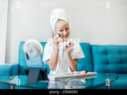 Kinderblogger. Junges Mädchen, das das Video für ihre Anhänger über Make-up filmt. Stockfoto