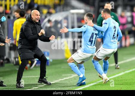 Manchester City Manager Pep Guardiola feiert mit Torschütze Phil Foden und Kyle Walker (rechts) ihr zweites Tor während des UEFA Champions League-, Viertelfinales-, zweiten Beinspieles im Signal Iduna Park in Dortmund. Bilddatum: Mittwoch, 14. April 2021. Siehe PA-Geschichte SOCCER man City. Das Foto sollte lauten: PA Wire via DPA. EINSCHRÄNKUNGEN: Nur redaktionelle Verwendung, keine kommerzielle Nutzung ohne vorherige Zustimmung des Rechteinhabers. Stockfoto