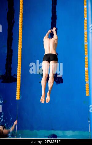 Männlicher professioneller Schwimmer im Schwimmbad Stockfoto