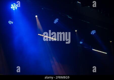 Mehrfarbiges Licht auf dunkler Bühne im Nebel Stockfoto