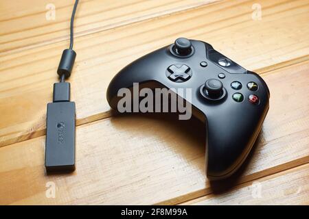 12. APRIL 2021 - BUENOS AIRES, ARGENTINIEN: Ansicht des schwarzen Xbox One Spielcontrollers und Receivers für PC auf Holztisch. Stockfoto