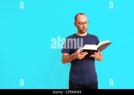 Der Mensch liest ein Buch konzentriert und Ausdruck auf seinem Gesicht, isoliert auf weißem Hintergrund. Stockfoto