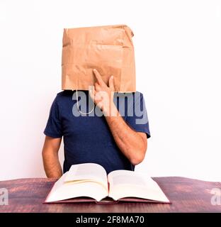 Glücklicher reifer Mann, der die Lösung für das fand, was er suchte, in einem Buch, das mit seinem Finger zeigte, isoliert auf dem Hintergrund. Stockfoto