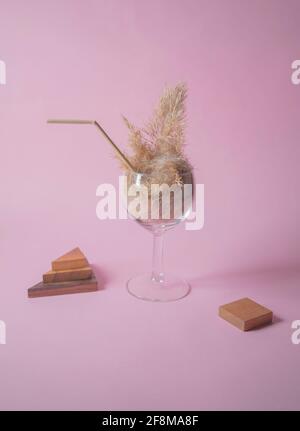 Pampas Gras Cocktail in einem Glas mit einem Stroh aus Pampastiel. Minimale abstrakte Komposition Hintergrund. Japanische Inneneinrichtung. Erfrischungsidee. Stockfoto