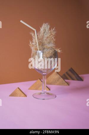 Pampas Gras Cocktail in einem Glas mit einem Stroh aus Pampastiel. Minimale abstrakte Komposition Hintergrund. Japanische Inneneinrichtung. Erfrischungsidee. Stockfoto