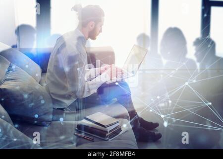 Businessman arbeitet auf dem Sofa mit seinem Laptop. Er ist im Smart Working Stockfoto