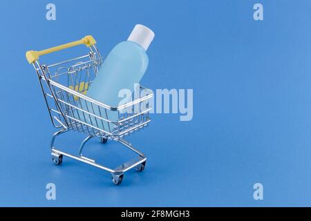 Warenkorb mit Desinfektionsmittel gefüllt Alcholol Flasche Kopierer Platz auf blau bg für Coronavirus vorbeugende Maßnahme, Schutz während Grippe vir Stockfoto