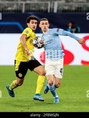 Dortmund, Deutschland. April 2021. Phil Foden (R) von Manchester City kontrolliert den Ball unter der Verteidigung von Mateu Morey aus Dortmund während eines UEFA Champions League-Viertelfinalmatches in der zweiten Etappe zwischen Borussia Dortmund und Manchester City am 14. April 2021 in Dortmund. Quelle: Joachim Bywaletz/Xinhua/Alamy Live News Stockfoto