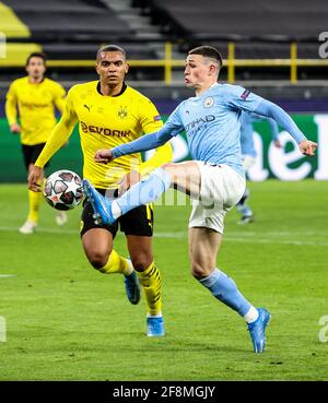 Dortmund, Deutschland. April 2021. Phil Foden (R) von Manchester City kontrolliert den Ball unter der Verteidigung von Manuel Akanji aus Dortmund während eines UEFA Champions League-Viertelfinalmatches in der zweiten Etappe zwischen Borussia Dortmund und Manchester City am 14. April 2021 in Dortmund. Quelle: Joachim Bywaletz/Xinhua/Alamy Live News Stockfoto