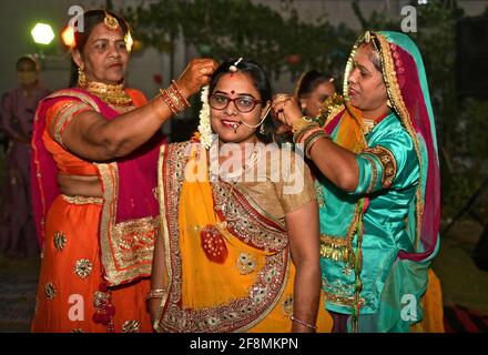 Beawar, Indien. April 2021. Rajasthani Frauen, die ihr Make-up vor der Anbetung während Sinjara Feiern am Vorabend des Gangaur Teej Festival in Beawar. Während des Gangaur-Festes beten verheiratete Frauen und unverheiratete Mädchen die Hindu-Göttin Gauri an, die Gemahlin des Herrn Shiva. (Foto: Sumit Saleswat/Pacific Press) Quelle: Pacific Press Media Production Corp./Alamy Live News Stockfoto