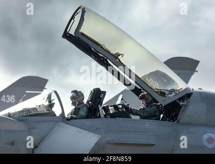 RAF Coningsby Lincolnshire Typhoon Kampfjet-Piloten, die in das Cockpit-Baldachin steigen, öffnen sich und sind bereit für den Start von Navigationswaffen. Dramatischer Himmel eutofighter Stockfoto