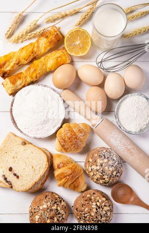 Vertikale Aufnahme von Zutaten in die Herstellung von Brot und frisch gebacken Brot auf dem Tisch Stockfoto